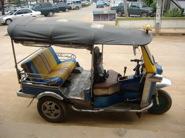 A tuk tuk in front of a guest house