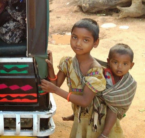 Older sibling (usually a girl) taking care of younger one in Shivrajpur, Jharkhand.